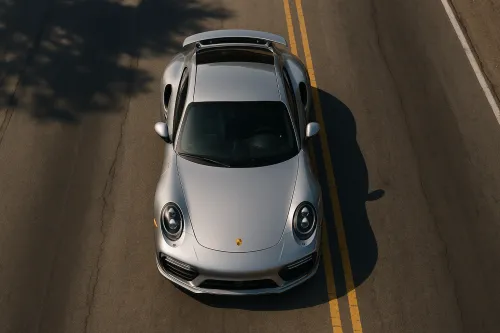 Shimmering Silver Porsche 911 on a Country Road During the Day
