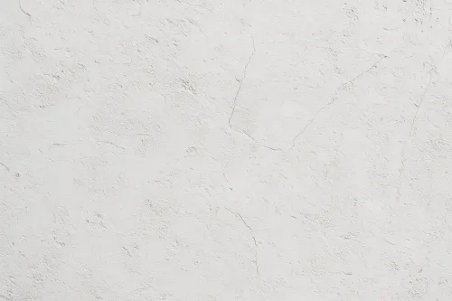 Pared blanca con textura y grietas, creando un efecto visual interesante