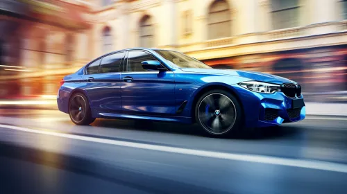 Современный синий седан BMW, движущийся по улице в городском окружении