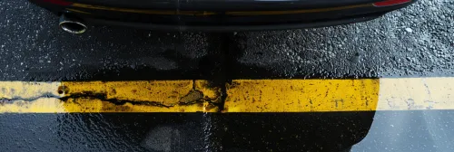 Primer plano de la marca en la carretera con reflejos y gotas de agua