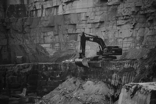 Excavadora CAT trabajando en la cantera, extrayendo piedra y grava