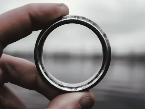 Metallic ring in hand against the water surface