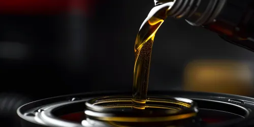 Moments of pouring golden oil into a black container