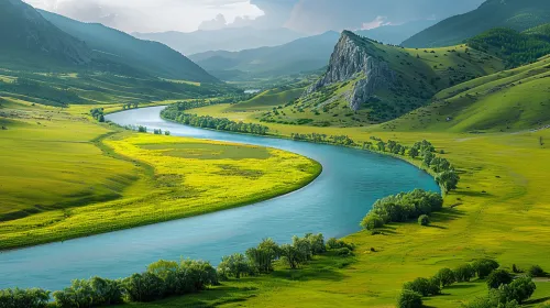 Emerald river winding through green mountains and meadows
