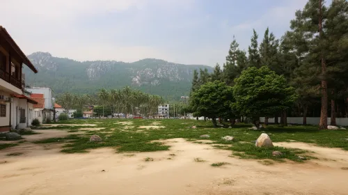 Wide view of mountains, greenery, and buildings amidst nature