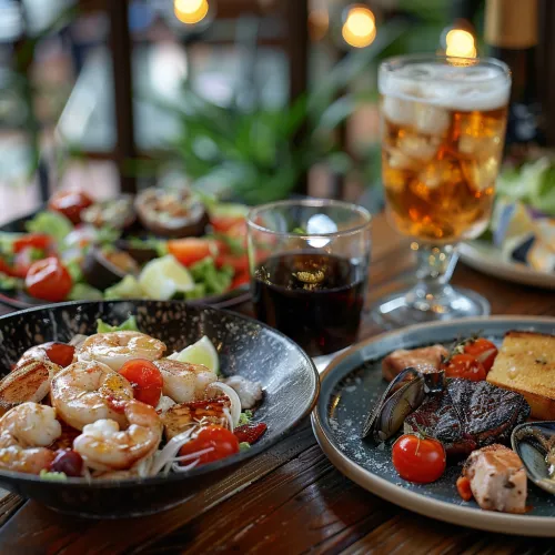 Image of a delicious dinner featuring seafood, salad, and beverages