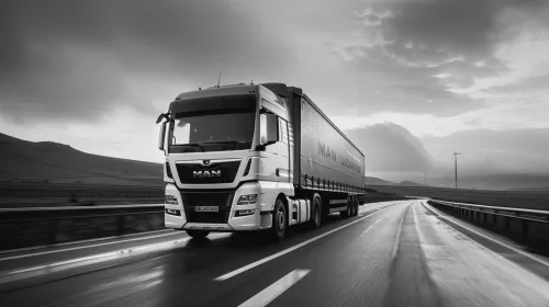 Gray MAN truck driving on a rainy road