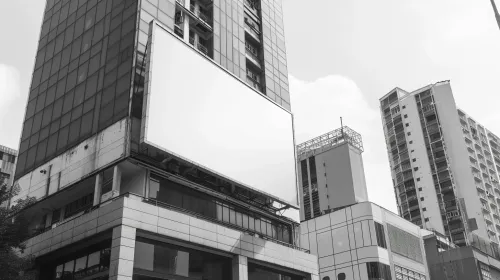Edificios altos y cartel publicitario vacío contra el fondo del cielo