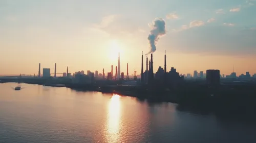 Chimeneas de fábricas y skyline de la ciudad al atardecer