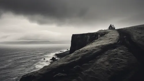 Ancient house on the edge of a cliff, surrounded by gray sky and sea