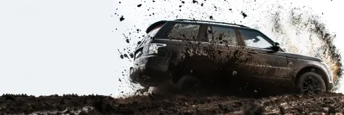 Powerful SUV driving on a muddy road, kicking up debris