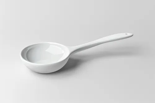 White ceramic spoon with a long handle on a gray background