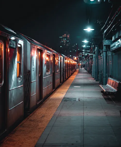Dark urban station with a subway train on the platform