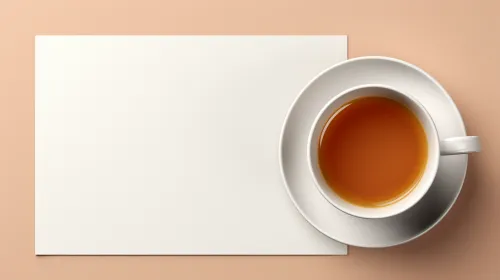 Taza de té junto a una hoja de papel blanco sobre fondo pastel
