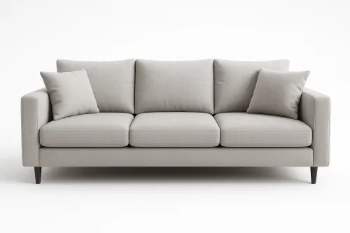Elegante sofá gris con varios cojines suaves sobre un fondo claro