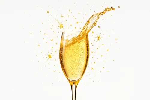 Copa con bebida, chispas y salpicaduras alrededor sobre fondo blanco