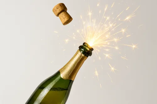 Шампанское открывается, пробка взлетает, искры разлетаются в воздухе