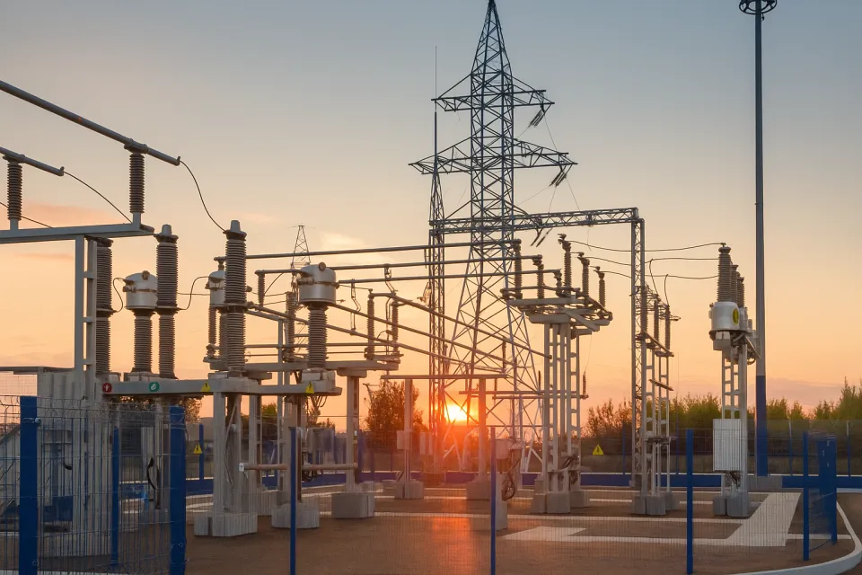 Substation with structures and high-voltage wires at sunset