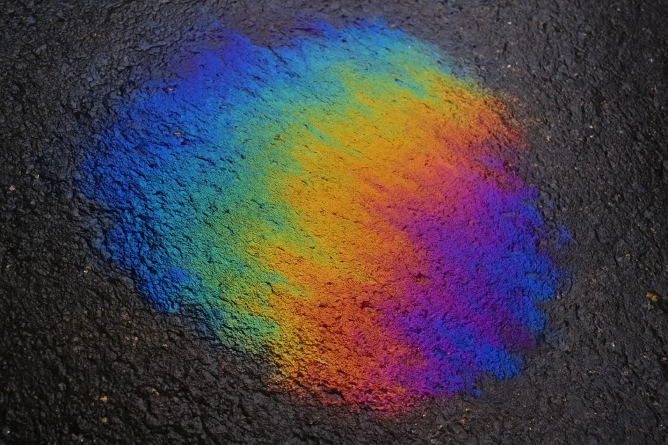 Dibujo multicolor sobre un asfalto negro, creado con polvos de colores
