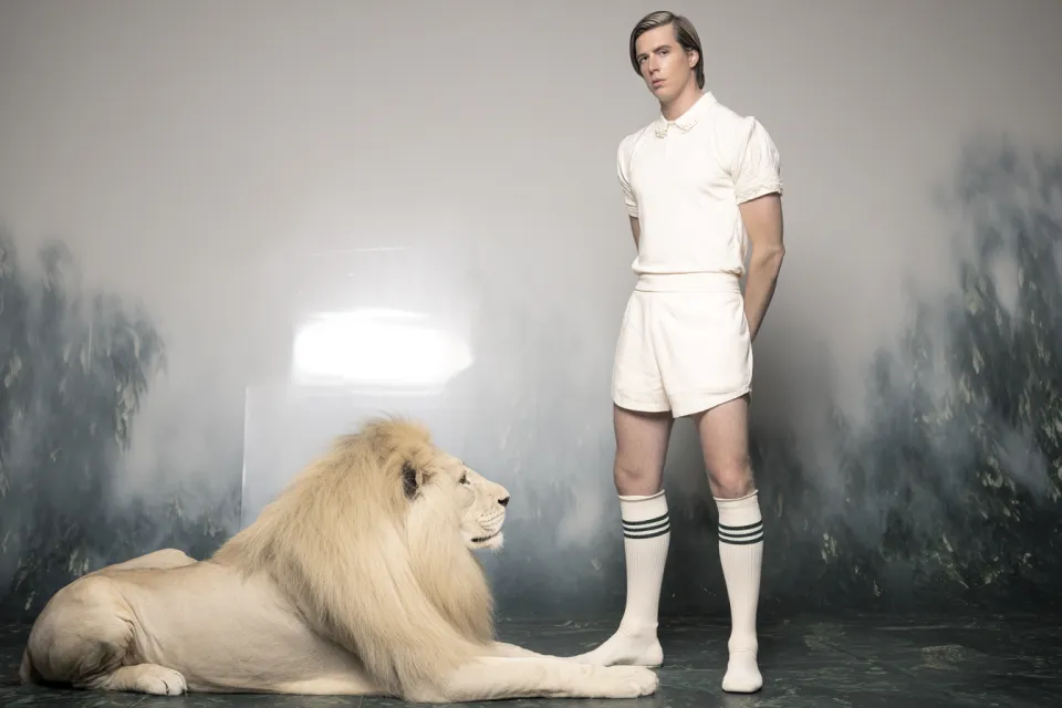 Fotografía estilizada de un hombre vestido de blanco con un león blanco