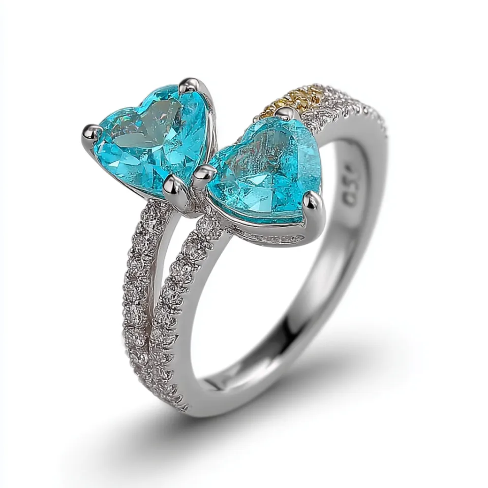 Ring with two blue heart-shaped stones and diamond embellishments