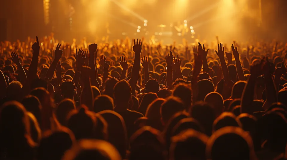 Vista de una gran multitud de espectadores en un concierto musical con las manos levantadas