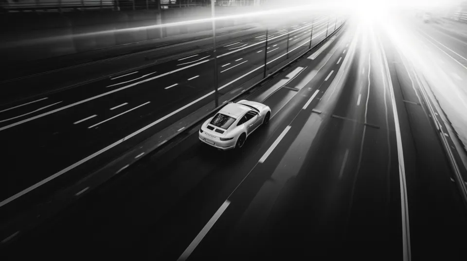 Coche deportivo moviéndose por una carretera oscura con luces borrosas