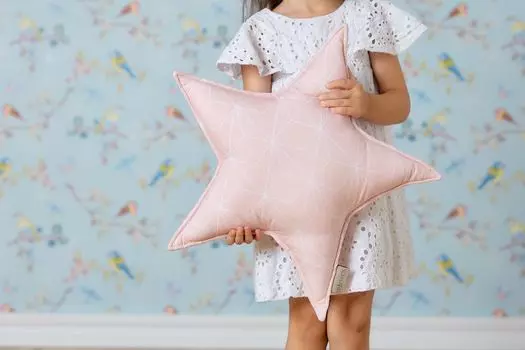 Украшение KraftKids в виде звезды-подушки с белыми тонкими бриллиантами на старом розовом фоне