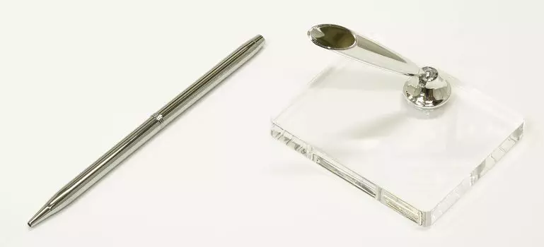 A brass rotating pen holder with a hole at the top for attaching gimmicks and a clear acrylic pen stand with a silver pen holder (Q-S6P3-1)