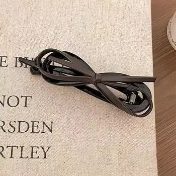 A fashionable and sweet leopard print updo headpiece with a leather bow twist clip on the back of a woman s head Size fits all