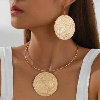 Большие круглые серьги и ожерелье в преувеличенном стиле с чеканными узорами и элегантными украшениями золотой