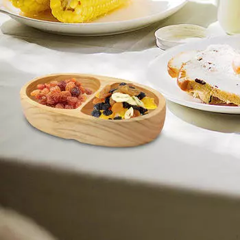 Деревянный поднос, разделенный печеньем, фруктовыми закусками, десертными тарелками, едой для