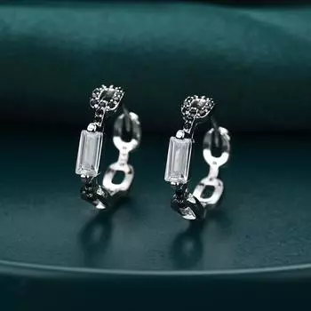 Ювелирные изделия в виде сережек-колец с черными и белыми камнями