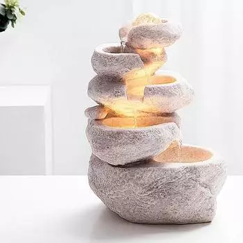 Каменистый фонтан с водой, стол для передачи денег перед открытием колеса тайфуна для отправки подарков белый