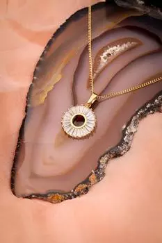 Круглое колье золотого цвета с камнем-багетом