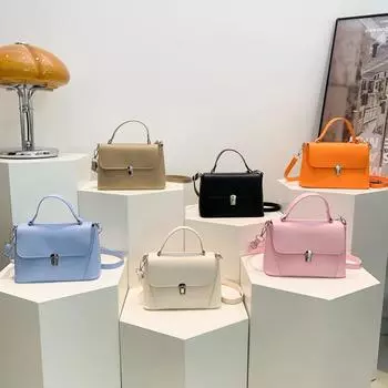 Летом 2024 года среди женщин будет популярна новая однотонная сумка.. Сумка-переноска с замком на одно плечо и текстурой Lock чёрный