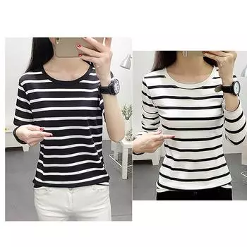 Модная пара носит полосатую женскую футболку с длинными рукавами и круглым вырезом