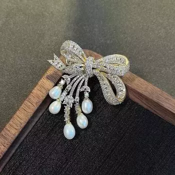 Позолоченная брошь-бантик с кисточкой, цирконом и жемчугом