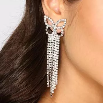 Сияющая и дикая девушка с длинными бриллиантовыми ушами и кольцом на ушах серебряный