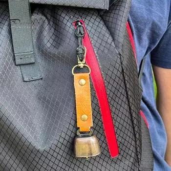 Уличный звонок с громким чистым звуком для отпугивания медведей. Искусственная кожа. Легко крепится и снимается. Пряжка для подвешивания на сумки, палатки, велосипеды, скребок для гриля.