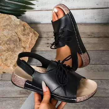 Женщина в шлепанцах на танкетке и босоножках на толстой подошве с застежкой-липучкой и изображением рта в форме рыбы на одной ноге 36 серебряный