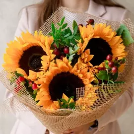 Букет из подсолнухов и гиперикума с фисташкой в упаковке