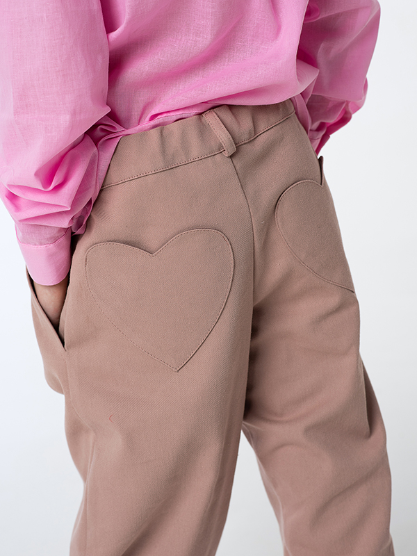 Бежево-розовые детские джинсы-бананы с карманами-сердечками