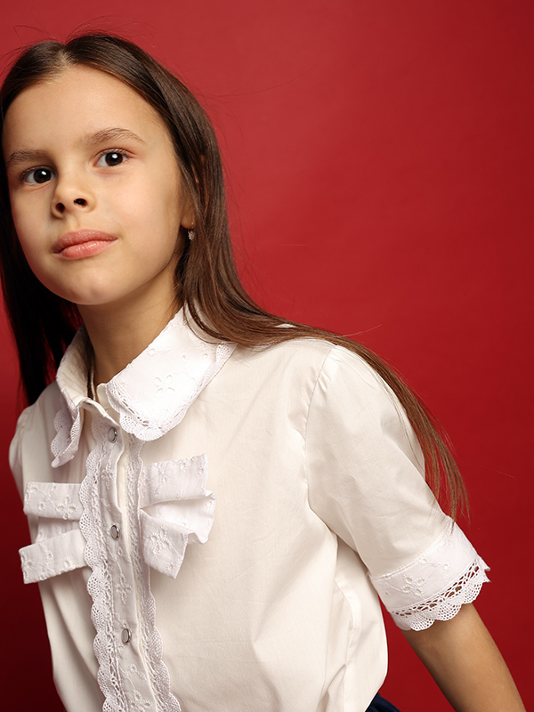 Нарядная белая школьная блузка со вставками из шитья с бантом на лифе