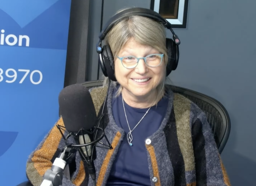 «Это наука!» – Президент Массачусетского технологического института говорит о важности американских научных исследований в эфире Бостонского общественного радио GBH. 2 Человек в наушниках говорит в микрофон в радиостудии, синий задний фон.