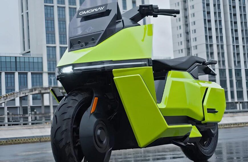 Ярко-зелёный электромотоцикл на фоне современных зданий.