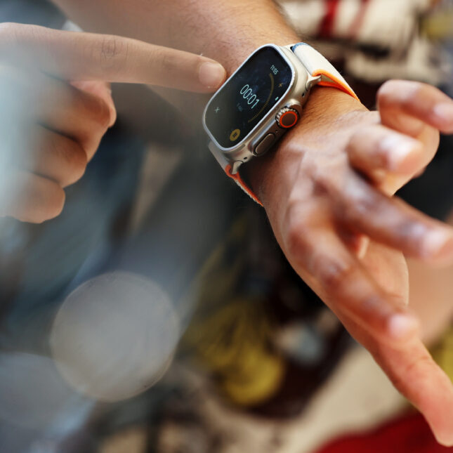 STAT+: Биотехнологическая компания использует Apple Watch для изучения своего препарата от болезни Паркинсона. 1 Человек управляет функциями на смарт-часах, устанавливает таймер.