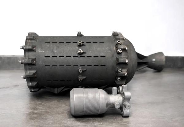 Металлические части ракетного двигателя на сером фоне, вид сбоку.