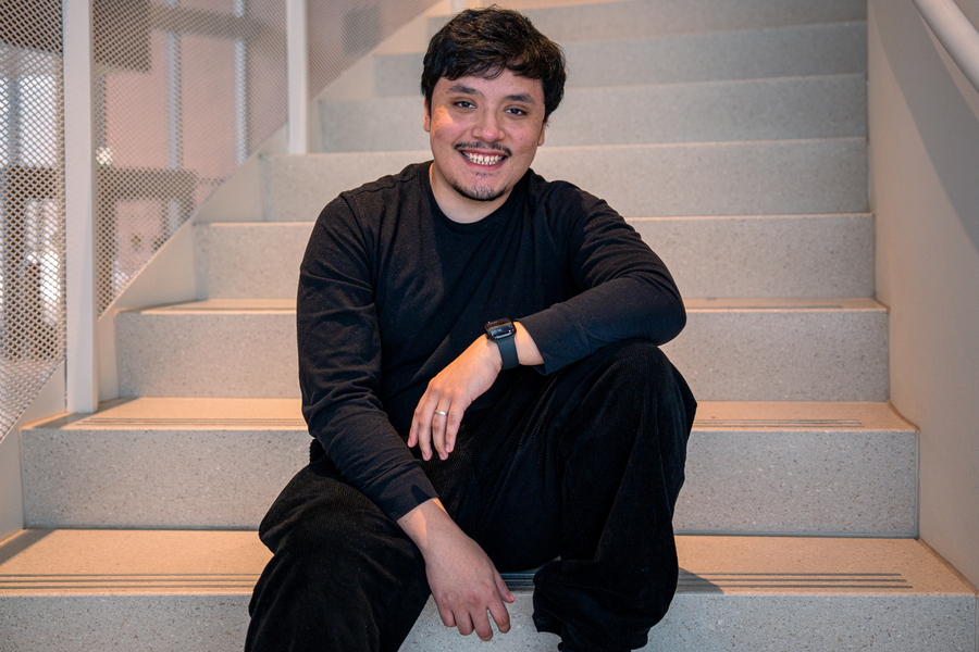 Человек в чёрном сидит на ступеньках, видны стильные часы на руке.