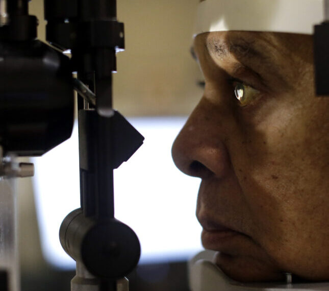 Человек проходит офтальмологический осмотр на щелевой лампе.